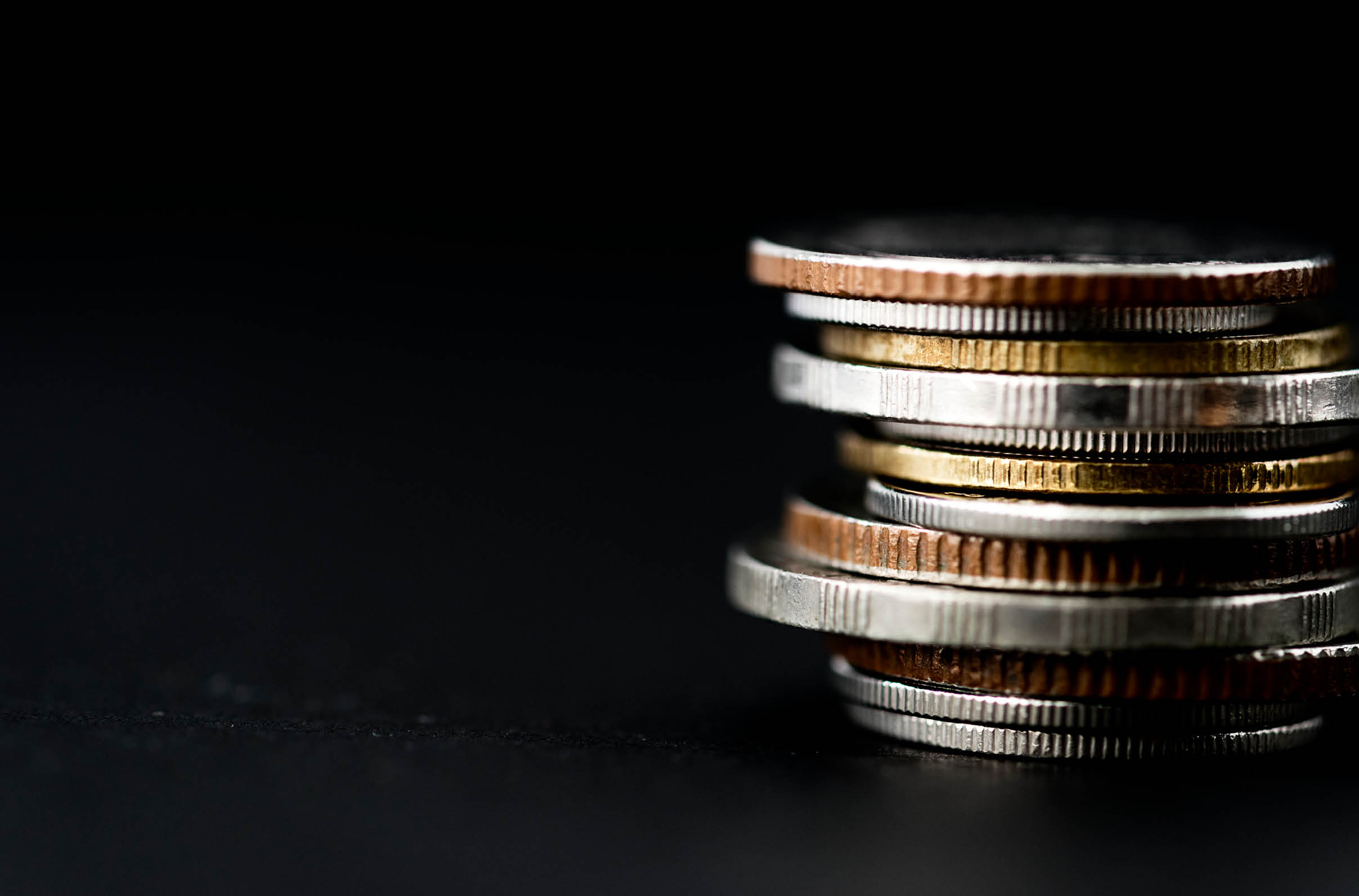 Closeup of coins stack isolated on black background